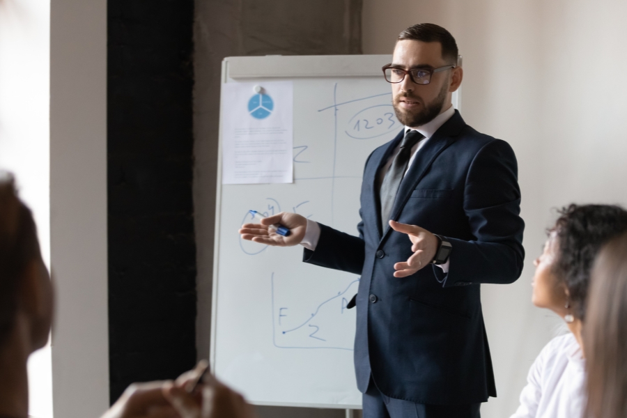 אדם מציג מצגת בישיבת עובדים.